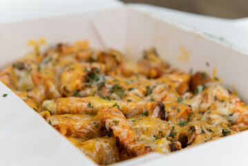 Fototapeta premium Hearty side order of buffalo chicken french fries covered in cheese and served in a take out box to eat on the go