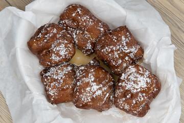 Overhead view of dessert treat for a sweet tooth consisting of deep fried cinnamon rolls covered in powdered sugar