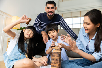 Happy asian family dad and child son building constructor from blocks.Loving parents having fun with  kids in the living room at home.