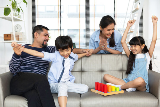 Happy asian family dad and child son building constructor from blocks.Loving parents having fun with  kids in the living room at home.