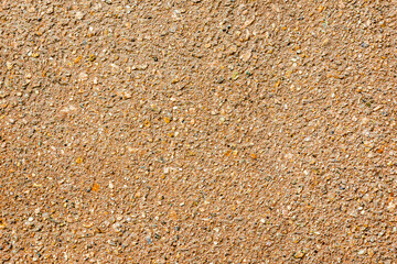 Texture of yellow sand with small pebbles. Sand Pattern