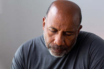 Portrait of a mature man looking sad and away from the camera.
