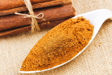 Cinnamon sticks with cinnamon powder on wooden background, Selective focus