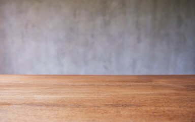 Wooden table top with blurred of concrete wall background