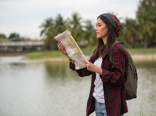 A beautiful Asian tourist is looking at a map to get to the right place.