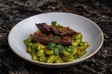 Entraña con pasta y salsa verde. Comida peruana