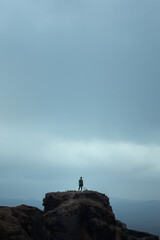 silhouette of a person standing on a rock