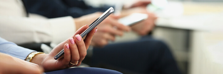 Female hands with manicure hold mobile phone device