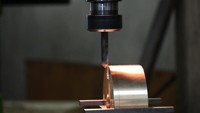 The close up  scene the chamfering process the brass parts with chamfer tool on NC milling machine.
