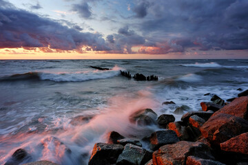 Zachód słońca nad kamienistym wybrzeżem Morza Bałtyckiego - obrazy, fototapety, plakaty