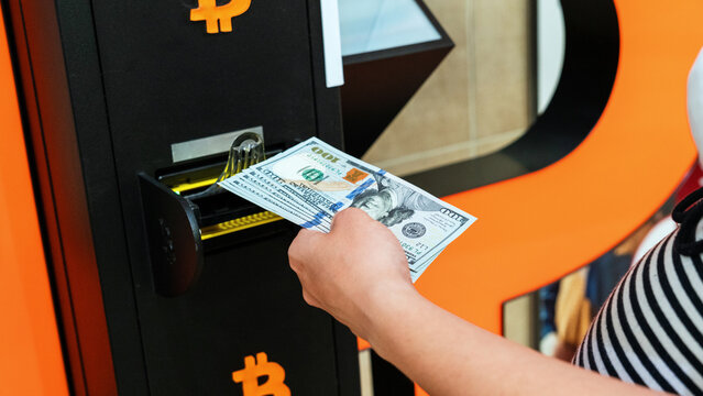 Bitcoin atm machine money. Usd hundred money payment on virtual crypto currency btc wallet. Woman withdraw american dollar bill cash. Atm machine finance and technology concept.