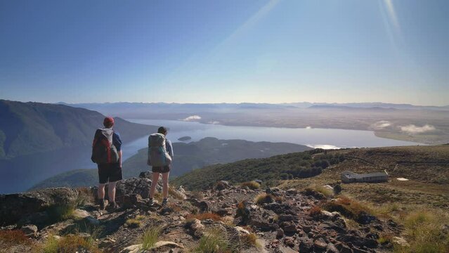 Static, hikers overlook Luxmore Hut and vast landscape, Fiordland, Kepler Track New Zealand