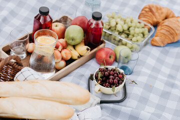 Fruits and drinks on the tablecloth at the picnic