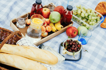 Fruits and drinks on the tablecloth at the picnic