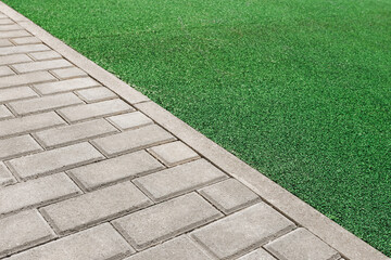 Paving with paving slabs borders on rubber crumb coating. Angle view. Selective focus.