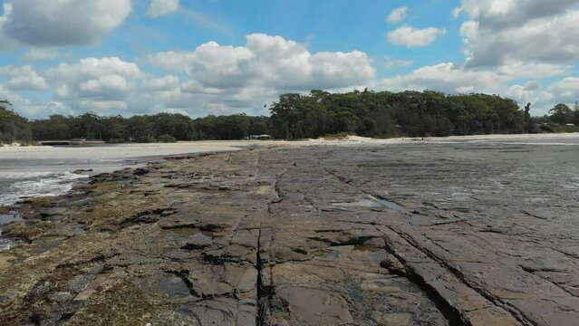 Drone video of Moona Moona Creek and Huskisson beach area after recent flooding with brown dirty water flowing into the bay