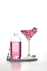 Iced Lavender cocktail  Purple cold drink in a glass and bottle on white board and white background lavender flowers. .Summer drink, lemonade.