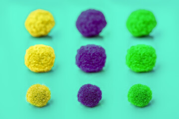 pattern with multi-colored pompons on a turquoise background