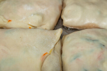 close-up of pies with filling on a frying pan