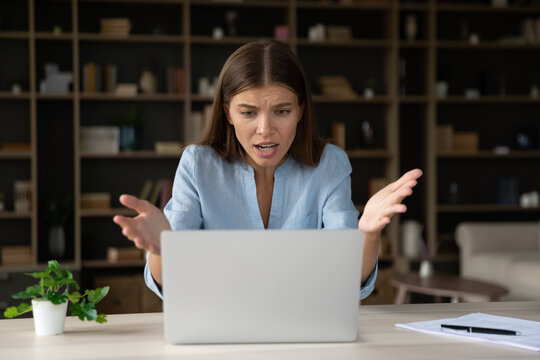 Annoyed stressed businesswoman having problem with laptop, broken or discharged device. Office employee looks at screen, read awful news feels shocked, unexpected app crash, unsaved data, spam concept