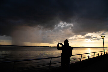 Fototapeta premium Traveller on the Constance lake promenade in the sunset.