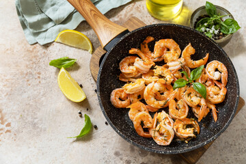 Spicy garlic chili Shrimps boiled shrimps and herbs, prawns in a frying pan with lemon. Seafood, shellfish. Copy space.
