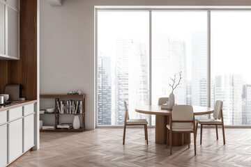 Light kitchen interior with eating table and chairs, kitchenware and window