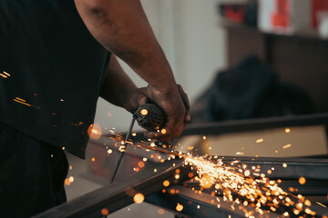 Close up on a man held an angle grinder to cut an iron with sparks