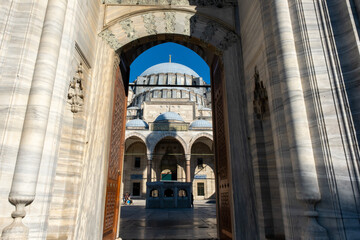 Obraz premium Suleymaniye Mosque entrance and dome view with a blue sky, old ancient structure, beautiful landmarks with mosque gate, Muslim and Islam concept: Suleymaniye Mosque, Istanbul, Turkey - June 25 2022