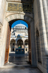 Fototapeta na wymiar Suleymaniye Mosque entrance with Quran text, old ancient structure, vertical view of mosque gate, Muslim and Islam concept, exterior: Suleymaniye Mosque, Istanbul, Turkey - June 25 2022