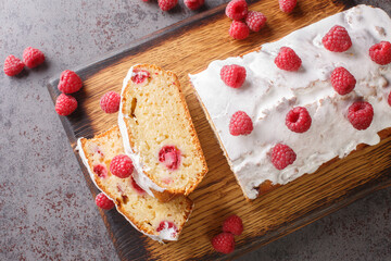 Delicious Raspberry loaf cake bread with lemon glaze close-up on a wooden board on the table. horizontal top view from above