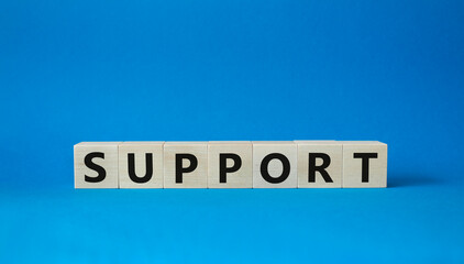 Obraz premium Support symbol. Concept word Support on wooden cubes. Beautiful blue background. Business and Support concept. Copy space.