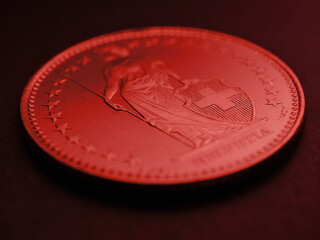 1 Swiss Franc coin closeup. Dark red tinted background or backdrop about economy, business or...
