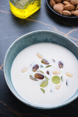 Close-up of spanish ajoblanco soup made of white bread, almonds, garlic, water and olive oil, vertical shot, selective focus