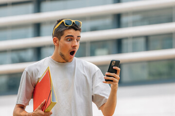 student looking surprised at mobile phone or smartphone