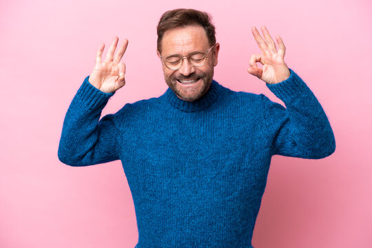 Middle age caucasian man isolated on pink background in zen pose