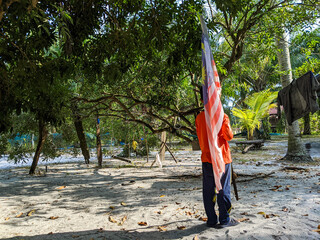 Perak, Malaysia, July 15 2022: A boy is holding a malaysia flag