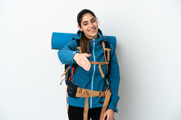 Young mountaineer man with a big backpack over isolated background shaking hands for closing a good deal