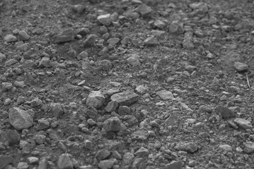 Stones in daylight for background. Concrete crushed stone on a dirt road in close-up.