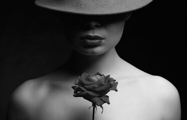 black and white portrait of Beautiful woman in hat holding Flower