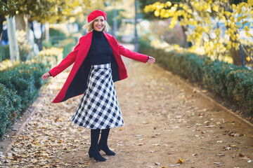 Stylish woman spinning around in park