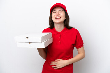Young Russian pizza delivery picking up pizza boxes isolated on white background smiling a lot