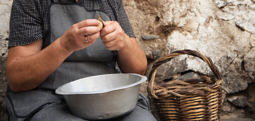 Grandma's hands, peeling potatoes with knife, heavy and hard working peeling potatoes