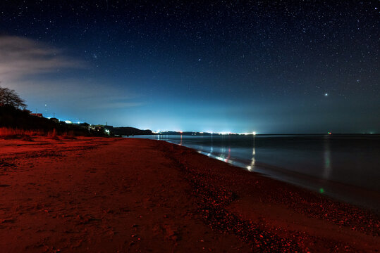 View of the sea at night with red light at the beach. Ochakov. Ukraine