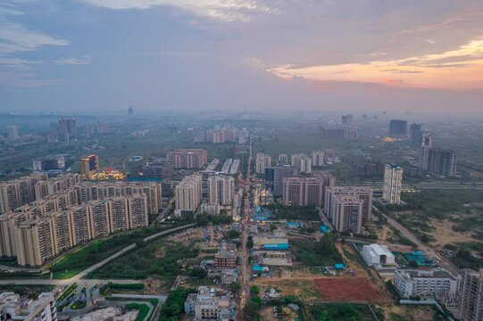 hyperlapse timelapse drone aerial shot showing busy traffic filled streets between skyscrapers filled with houses, homes and offices with a red sunset sky showing the hustle and bustle of life in