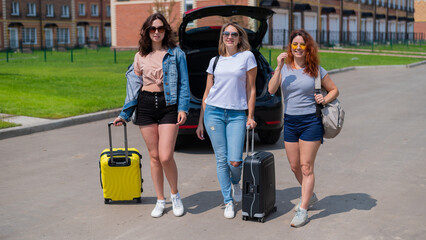 Fototapeta na wymiar Three friends are going to travel by car. Summer vacation
