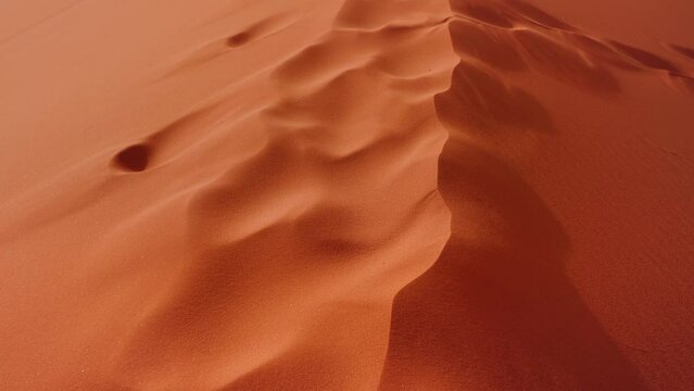 Orange red sand dune in Wadi Rum desert, closeup detail, sand glittering with light