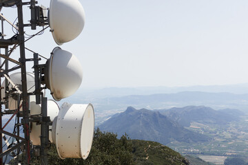 Detail of communications tower on top of mountain with view on background