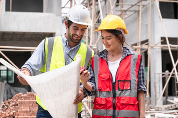 Mechanical Engineer team Working with paper work on construction home building site	
