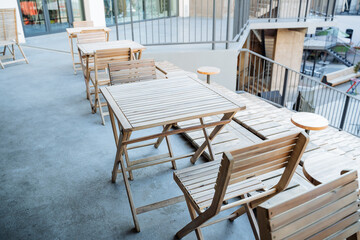 The interior of the outdoor cafe on the sidewalk, wooden tables, garden furniture, the design of the restaurant in the open air.